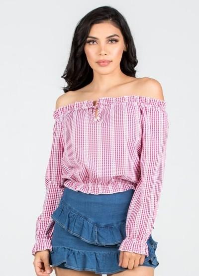 a woman in a pink dress standing on a bench