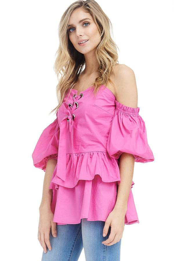 a woman in a pink dress standing in a field 